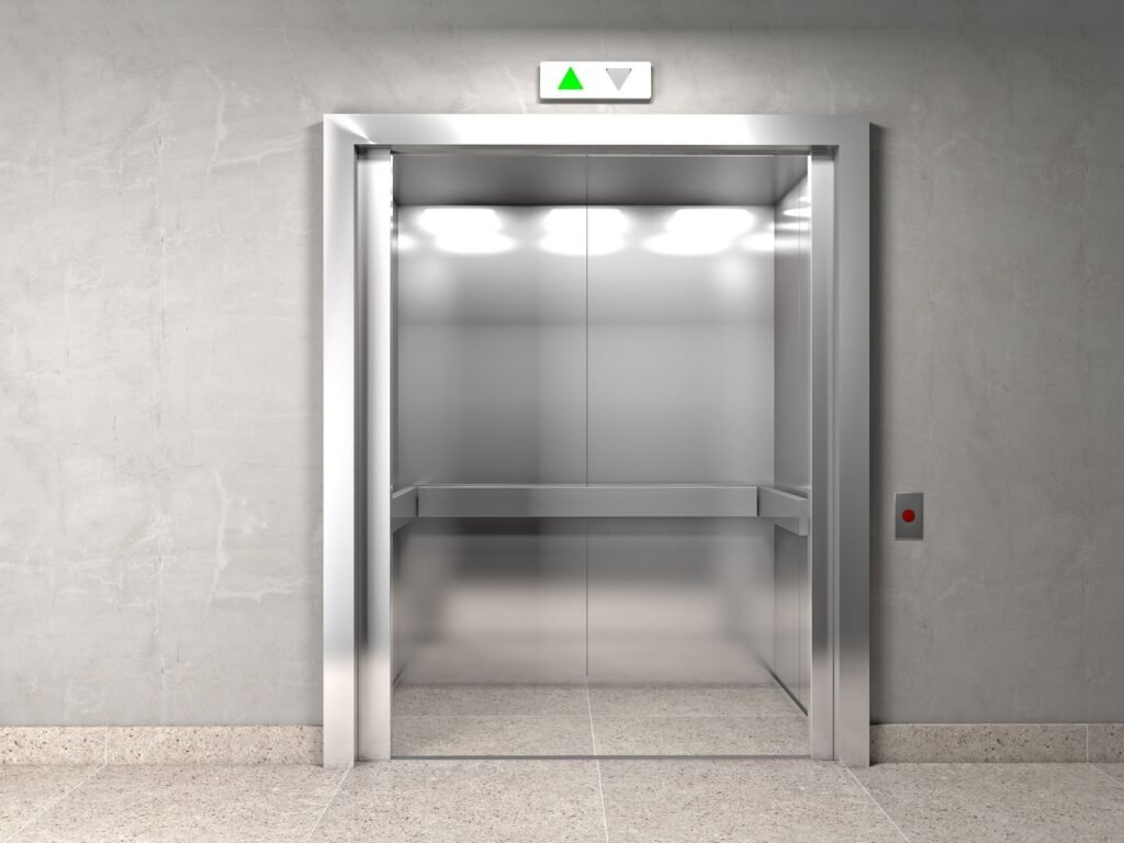 Cabine d’ascenseur moderne en inox brossé, portes ouvertes